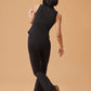 back of woman in black crew neck sleeveless top and black flare pants