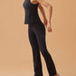 woman dancing in black crew neck sleeveless top and black flare pants