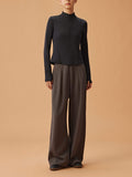 Woman wearing black half zip long sleeve top and dark gray sweatpants