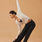 woman dancing in white cardigan, dark purple sports bra and black wide leg pants