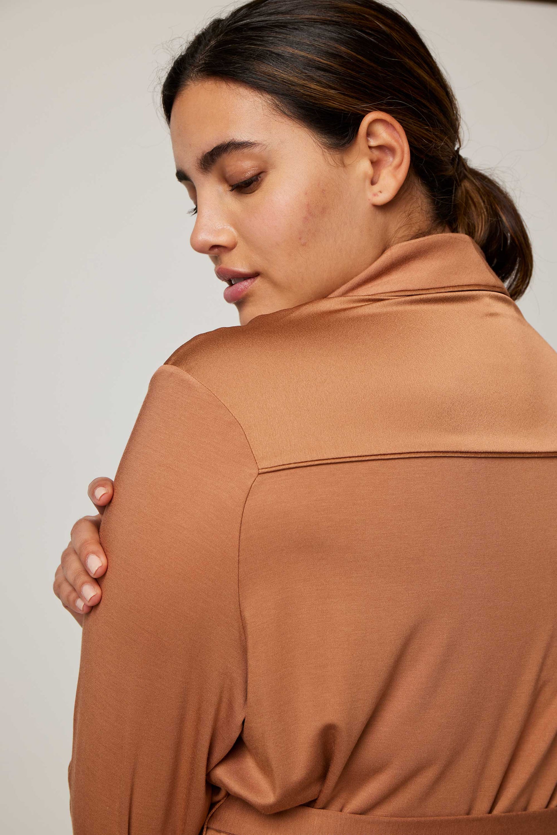 close up of the back of woman in caramel pajama top