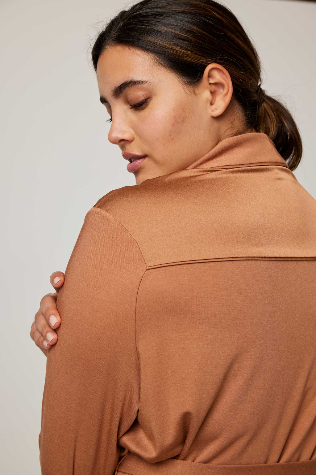 close up of the back of woman in caramel pajama top