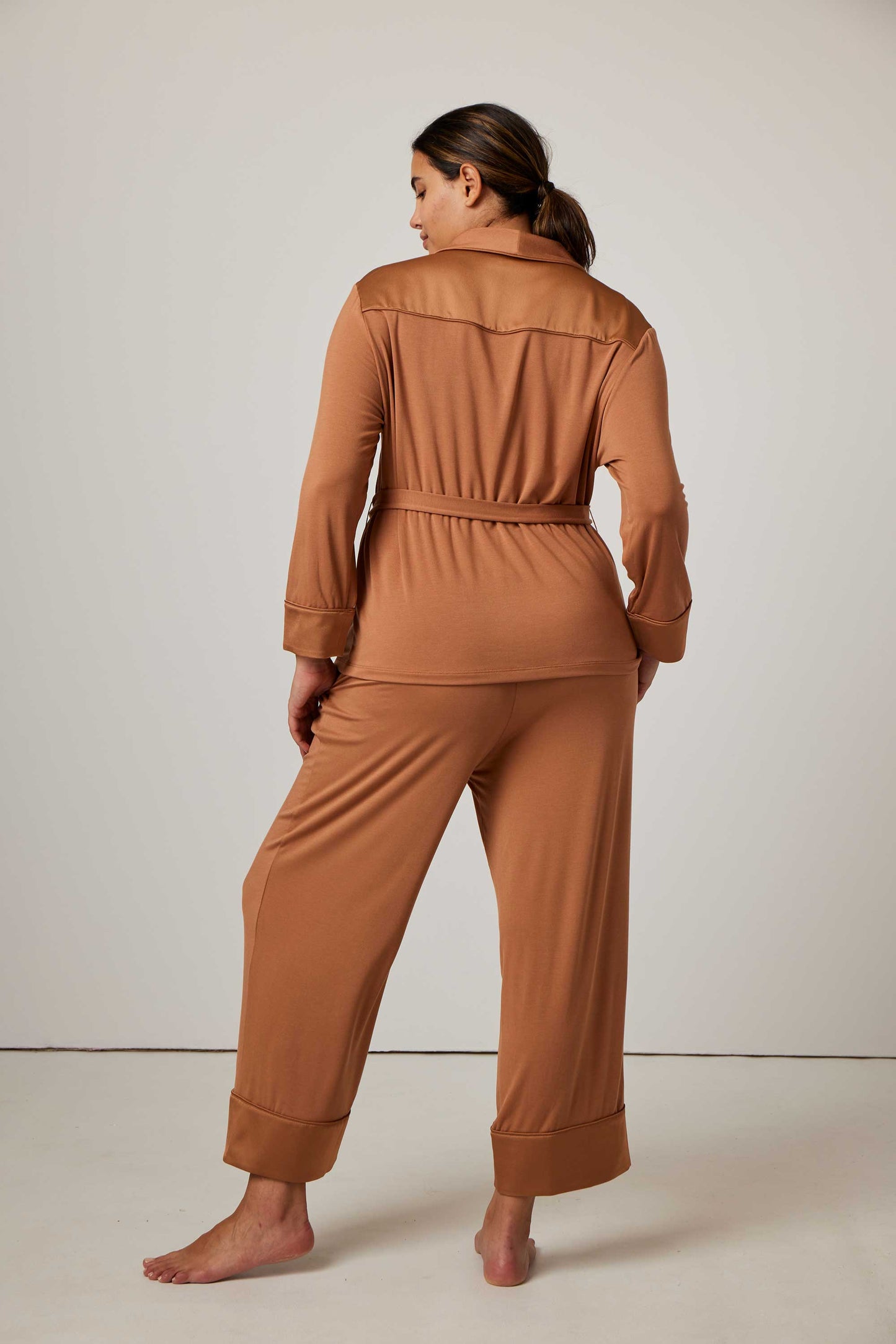 back of woman in caramel pajama set