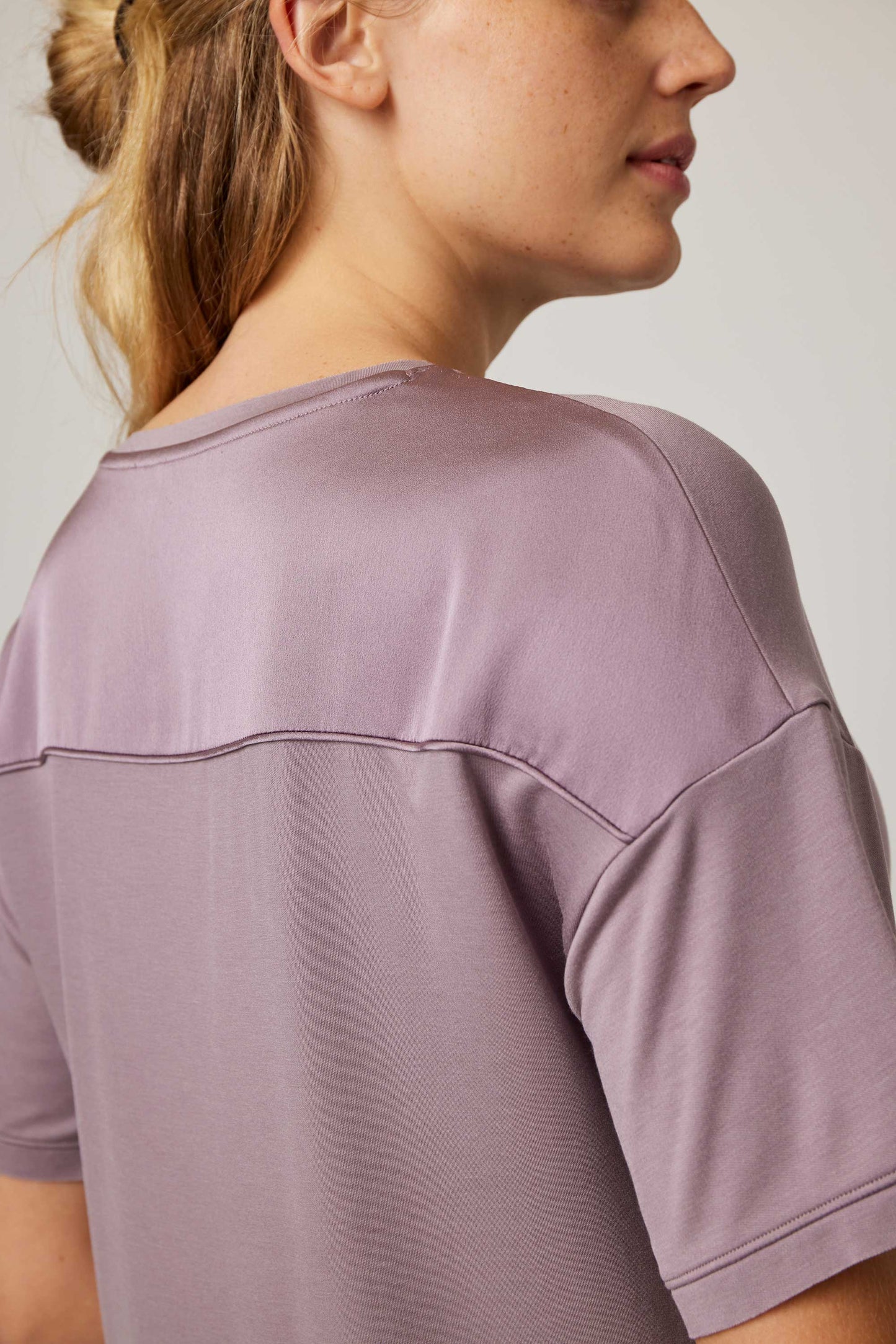 back of woman in purple pajama t-shirt