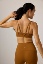back of woman in yellow sports bra and leggings