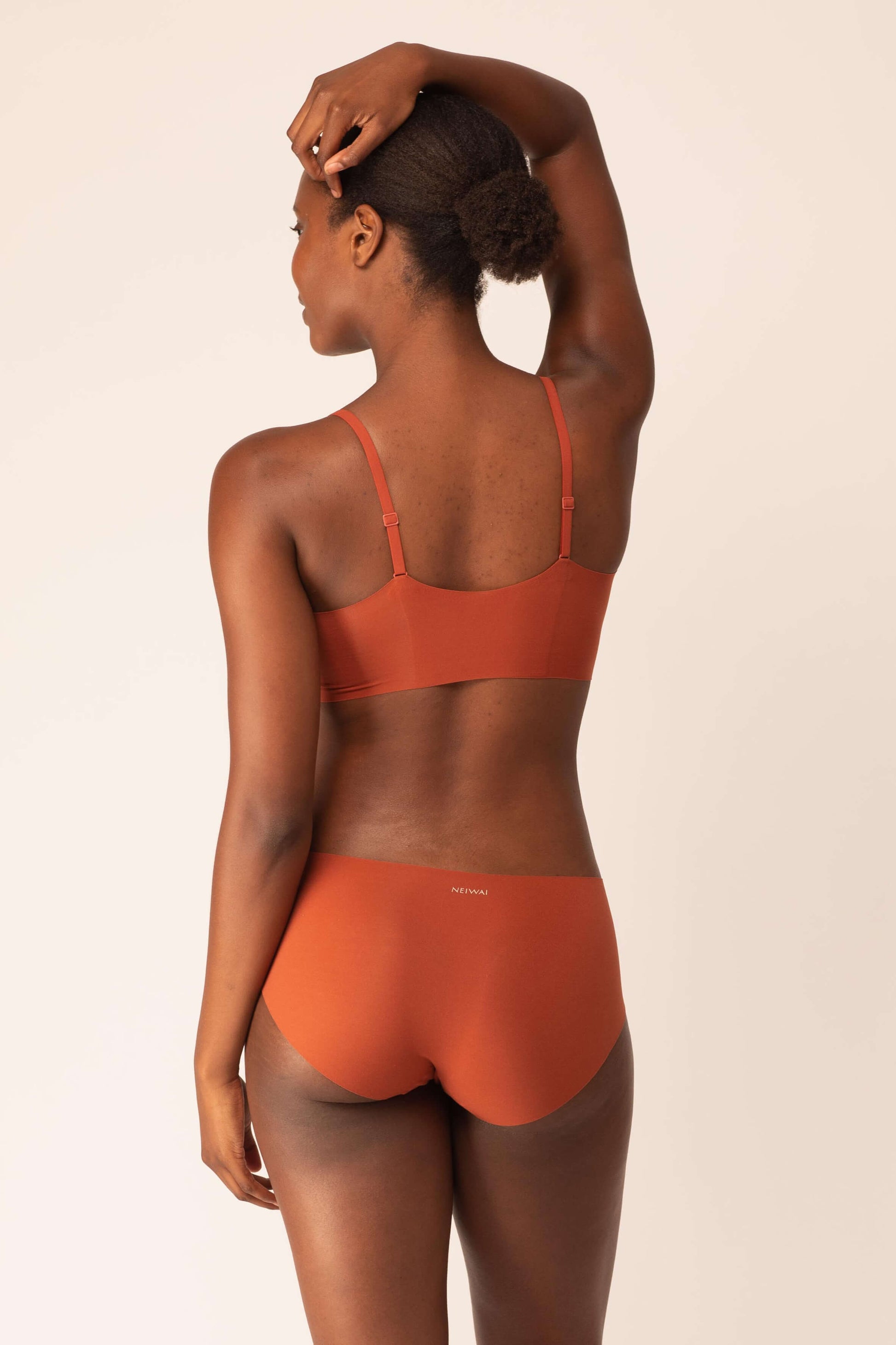 back of woman in tanned orange color bra and brief