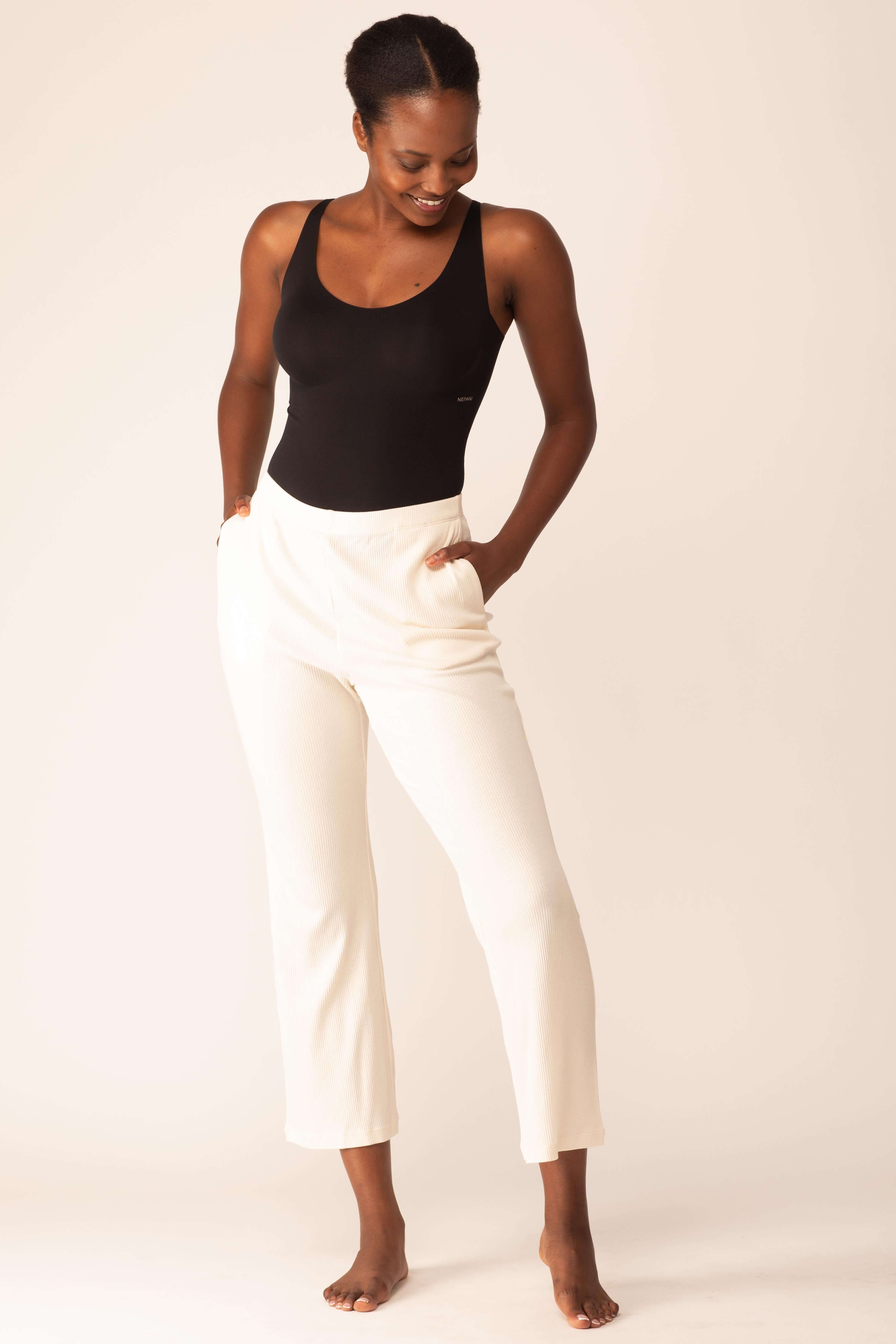 woman in black bodysuit and white pants