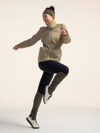 Model wearing green jacket, black leggings, and olive green leg warmers.