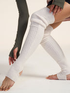 White knee-high leg warmer worn by a person on a plain background