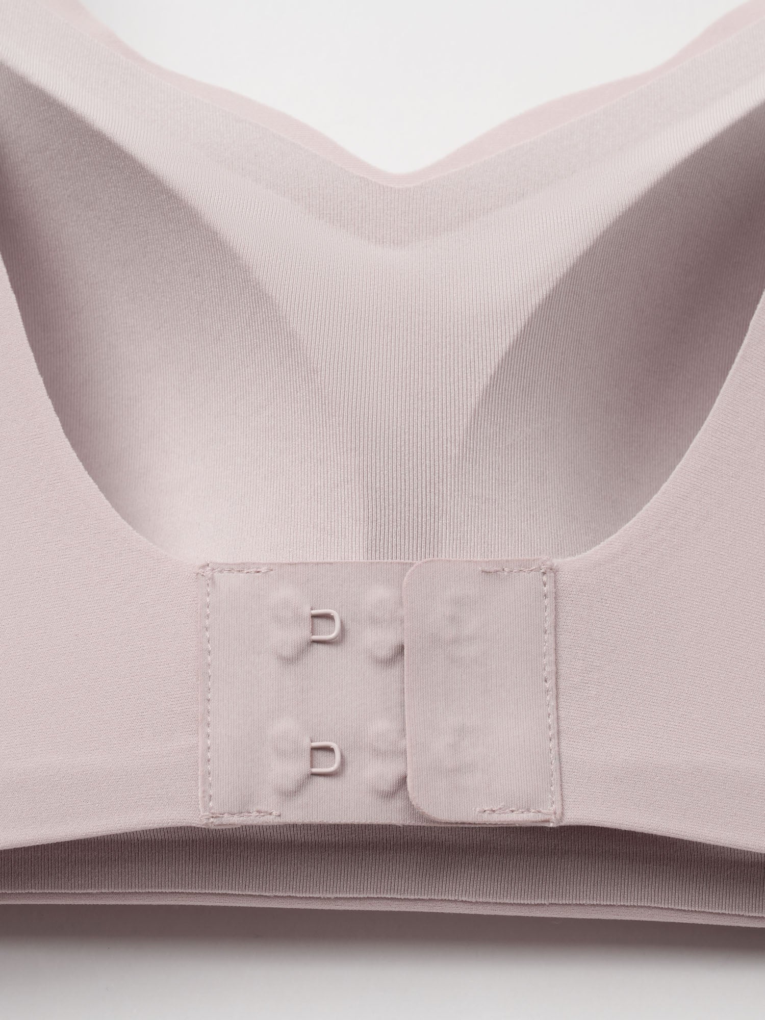 Close-up of a light pink bra on a white background