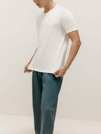 Man wearing white T-shirt and blue pants. White color.