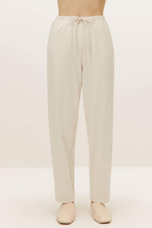 a pair of cream color pants with drawstring waist