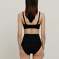 back of woman in black bra and brief