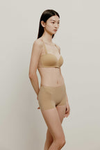 side of woman in tan bra and brief