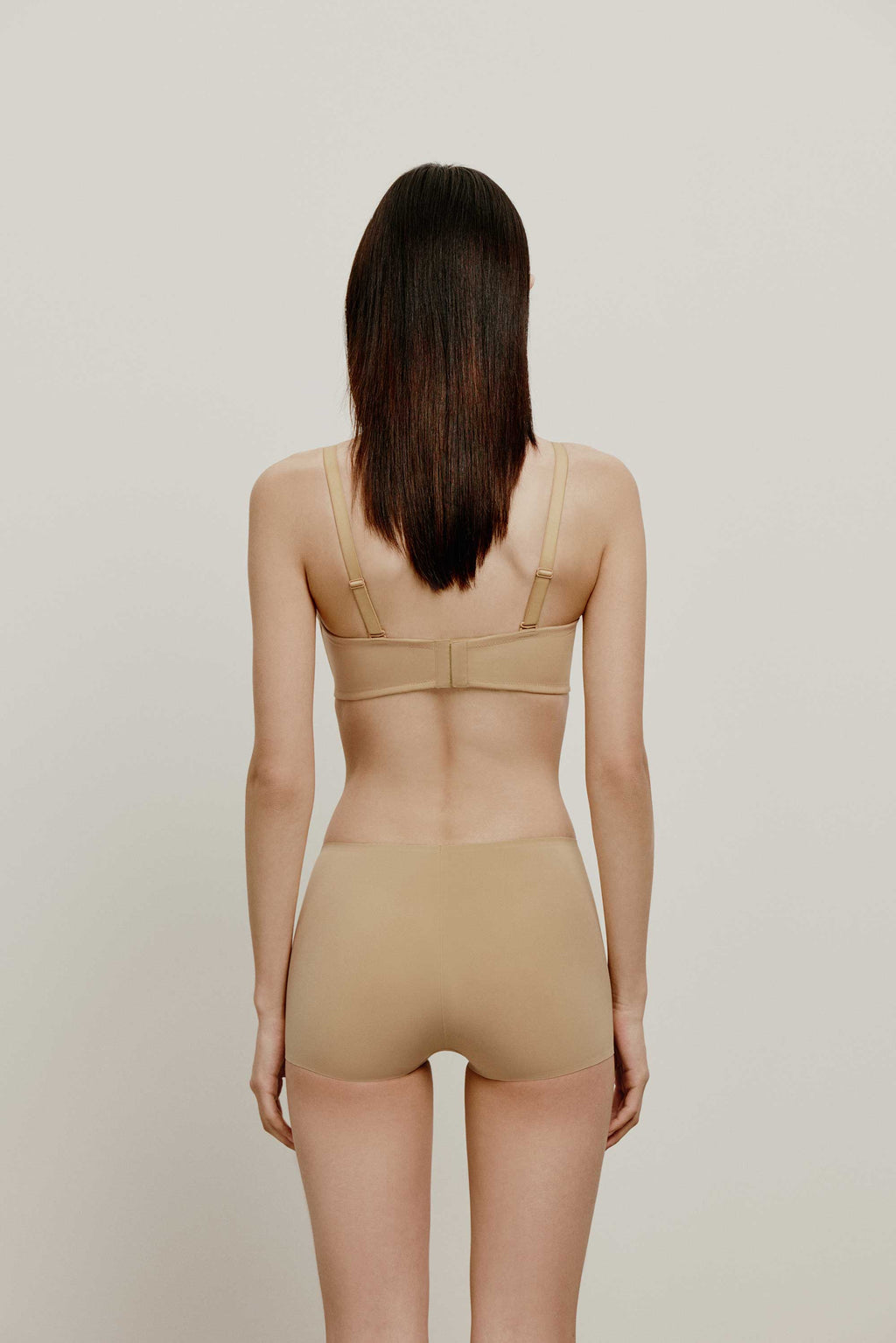 back of woman in tan bra and brief