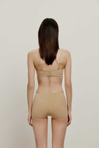 back of woman in tan bra and brief
