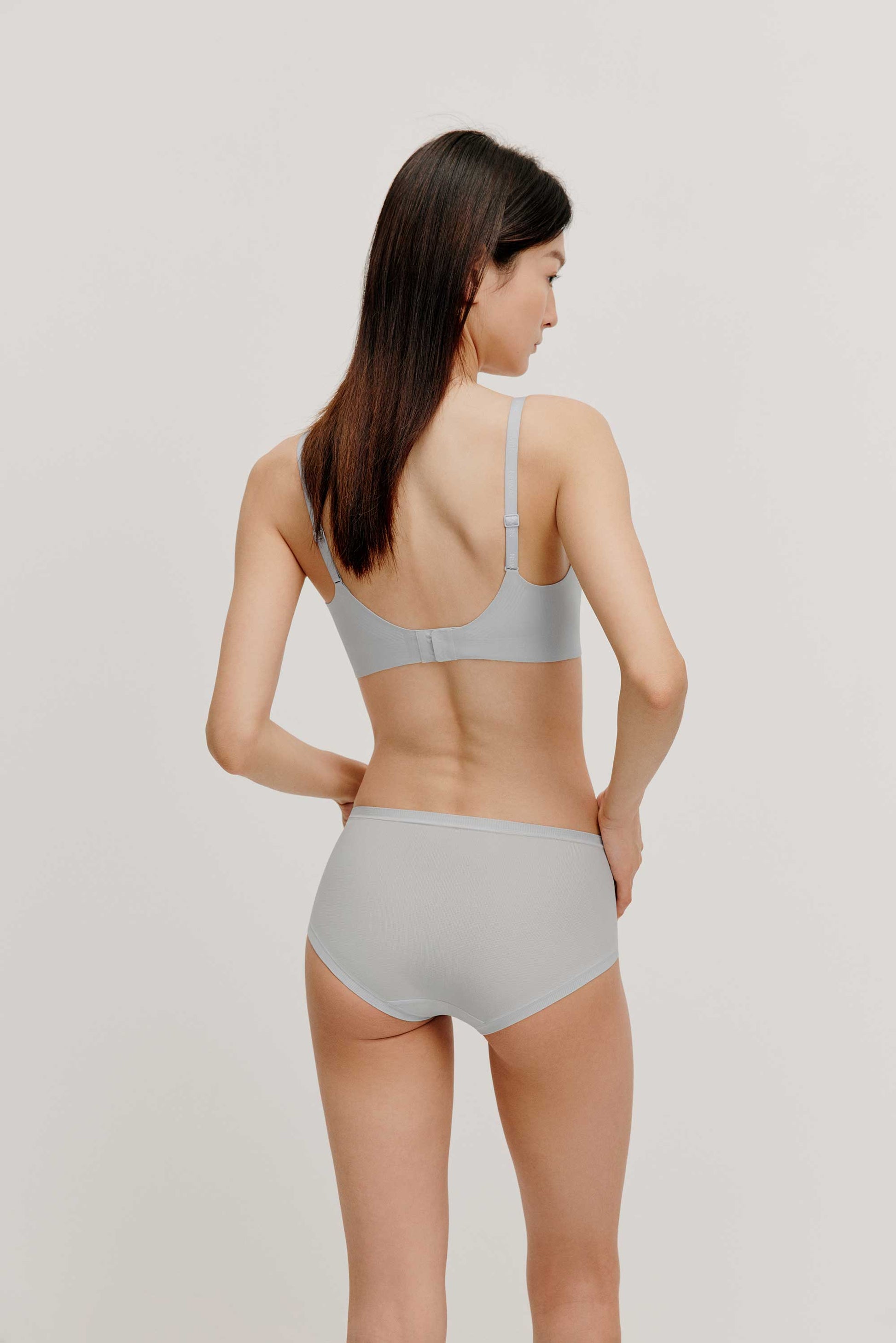 back of woman in light blue bra and brief