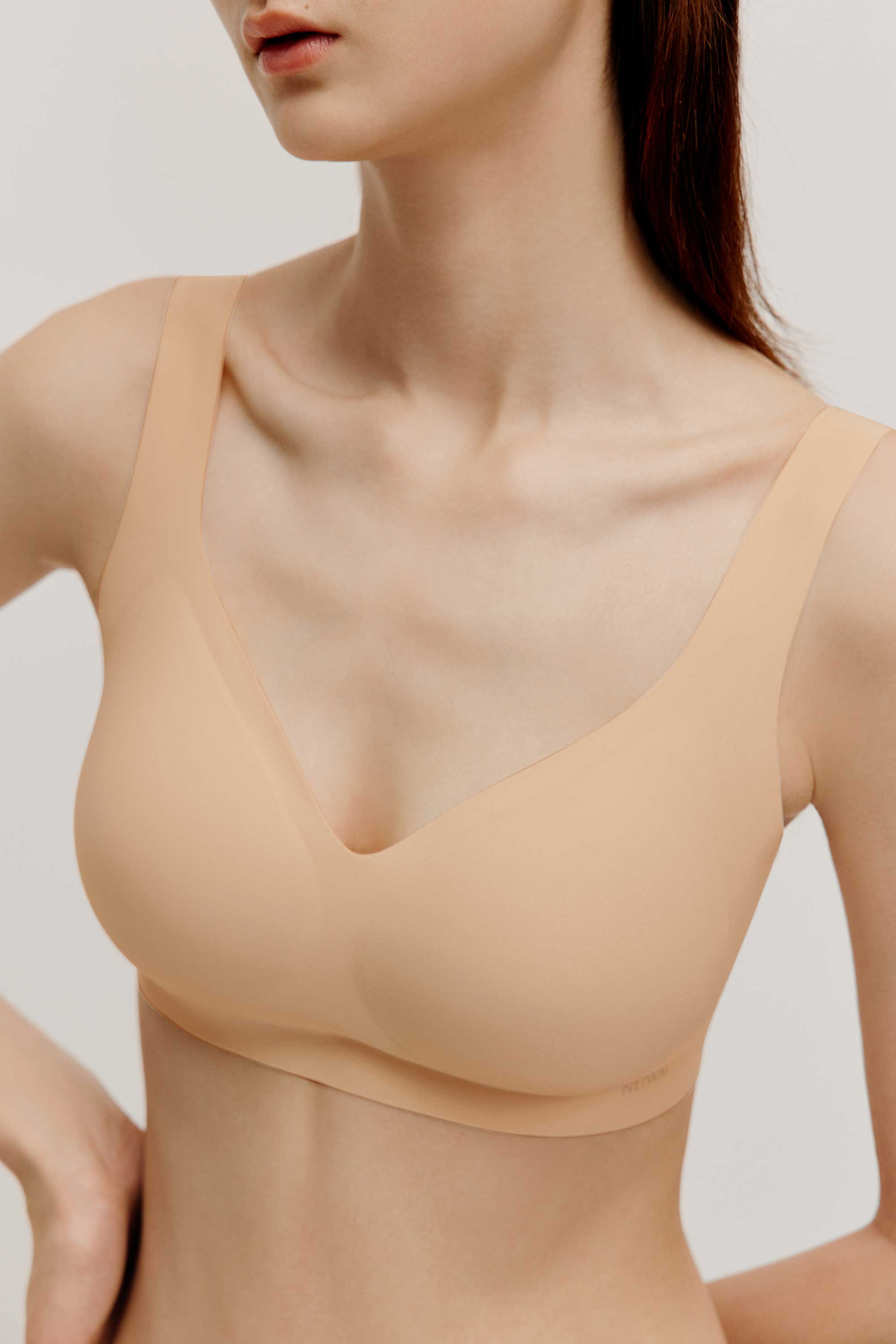 front close up of woman wearing light nude bra