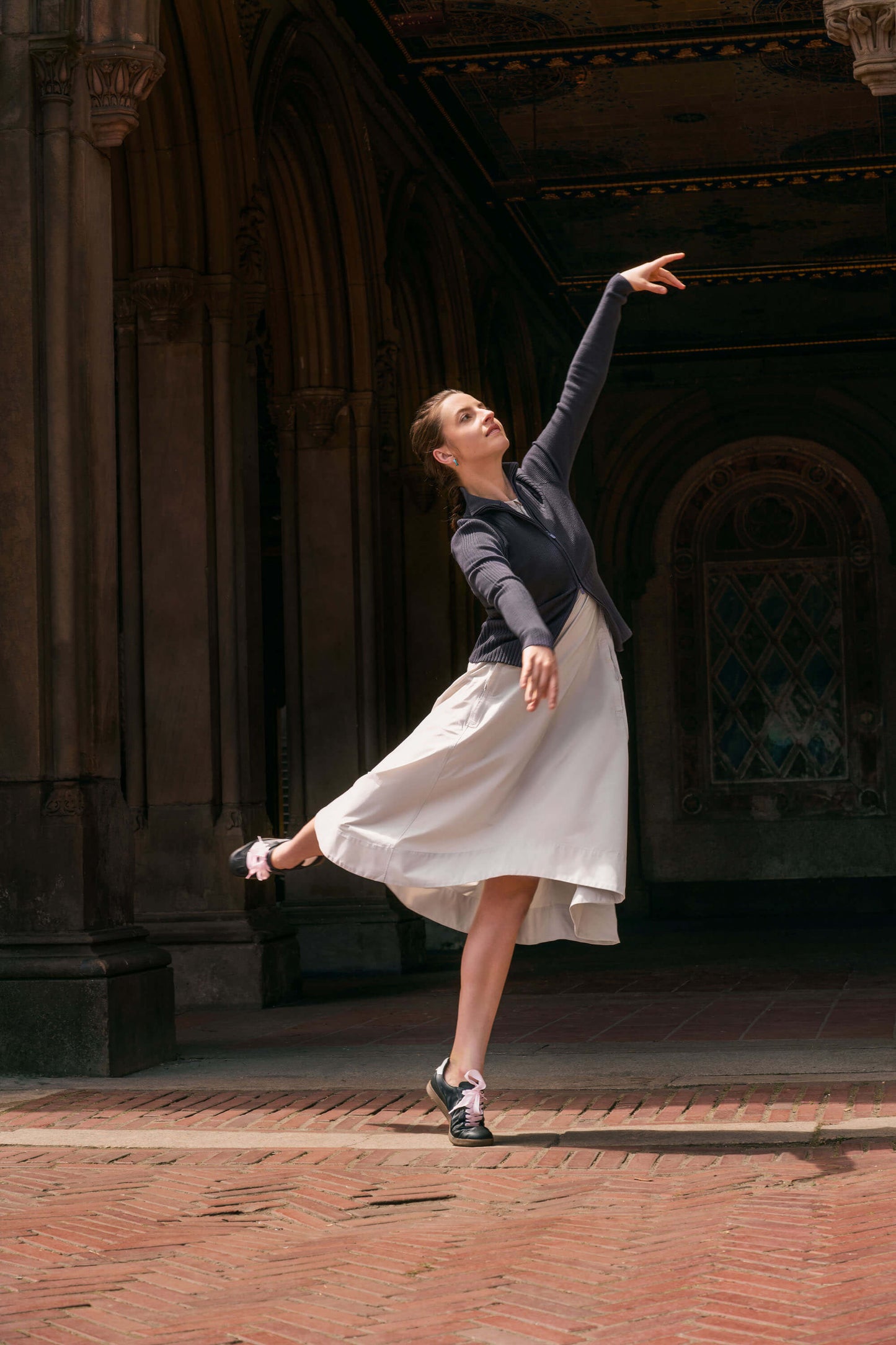 Dancer wearing beige dress and gray sweater