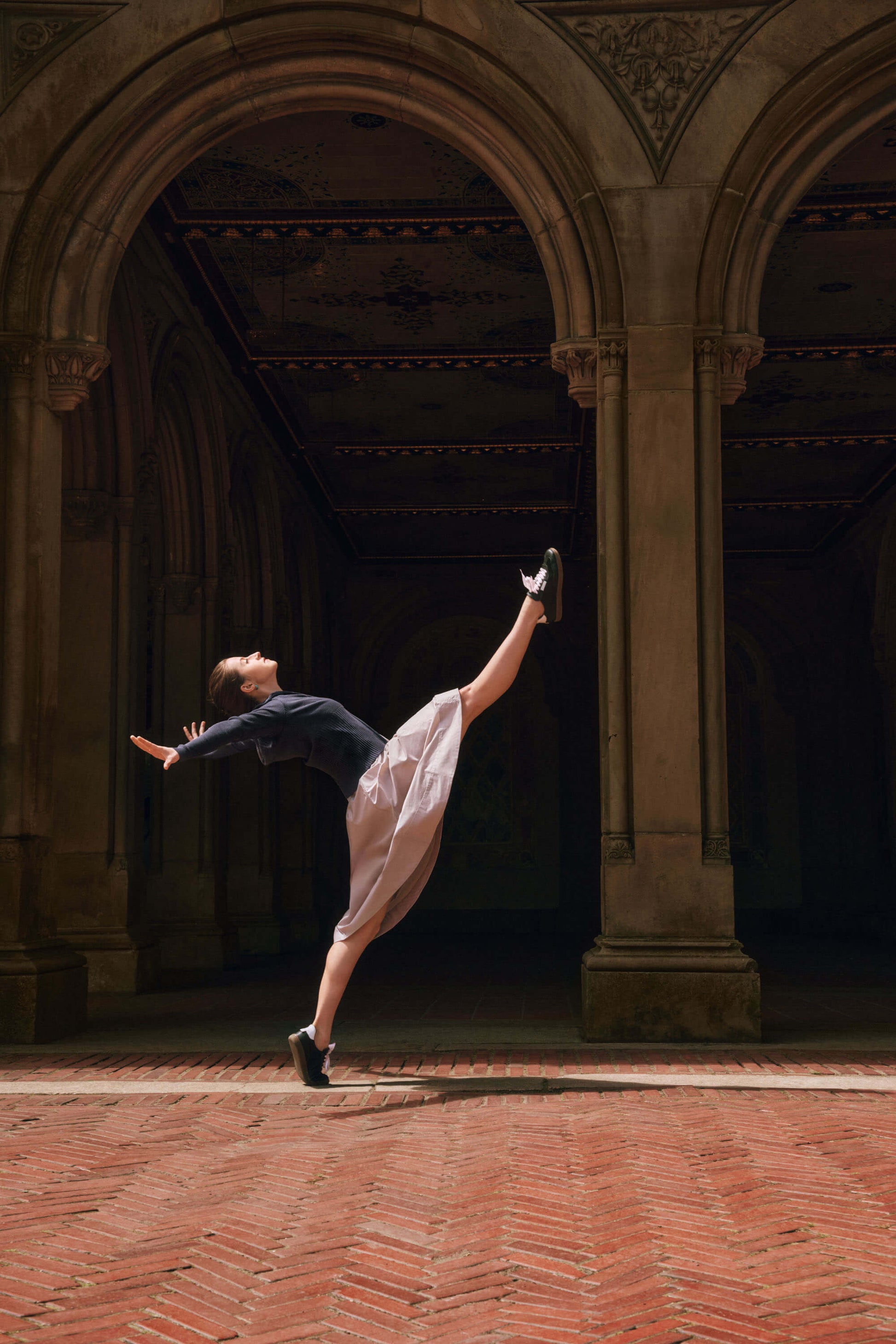 Dancer wearing beige dress and gray sweater