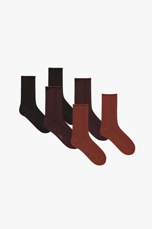 Flat lay image of three pairs of socks, one black, one dark purple, and one brown