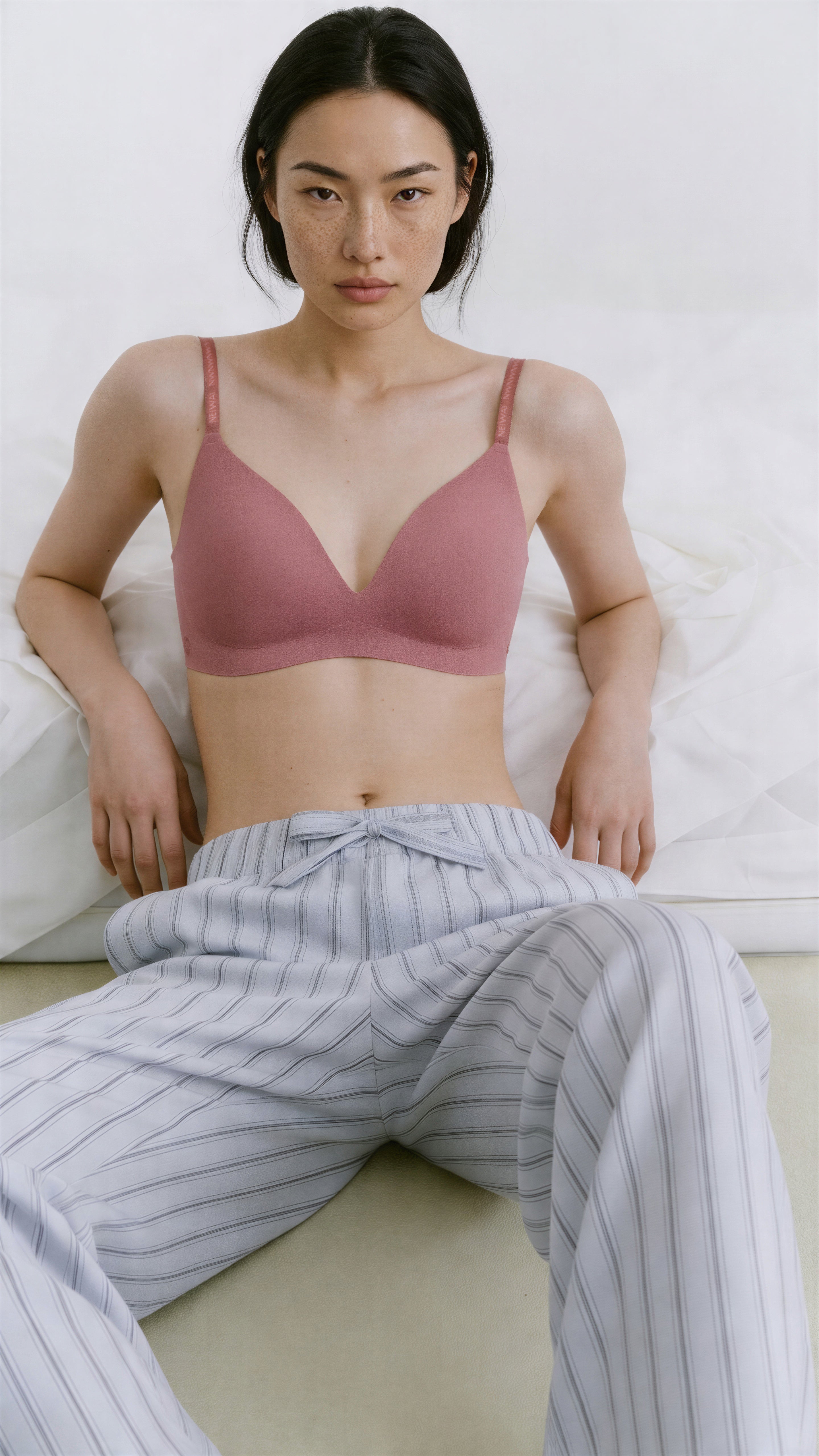 Woman wearing a pink bralette and striped pants on a white background,Taro Pink