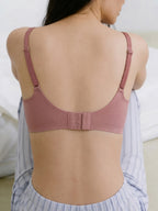 Person wearing a pink bra with a white background