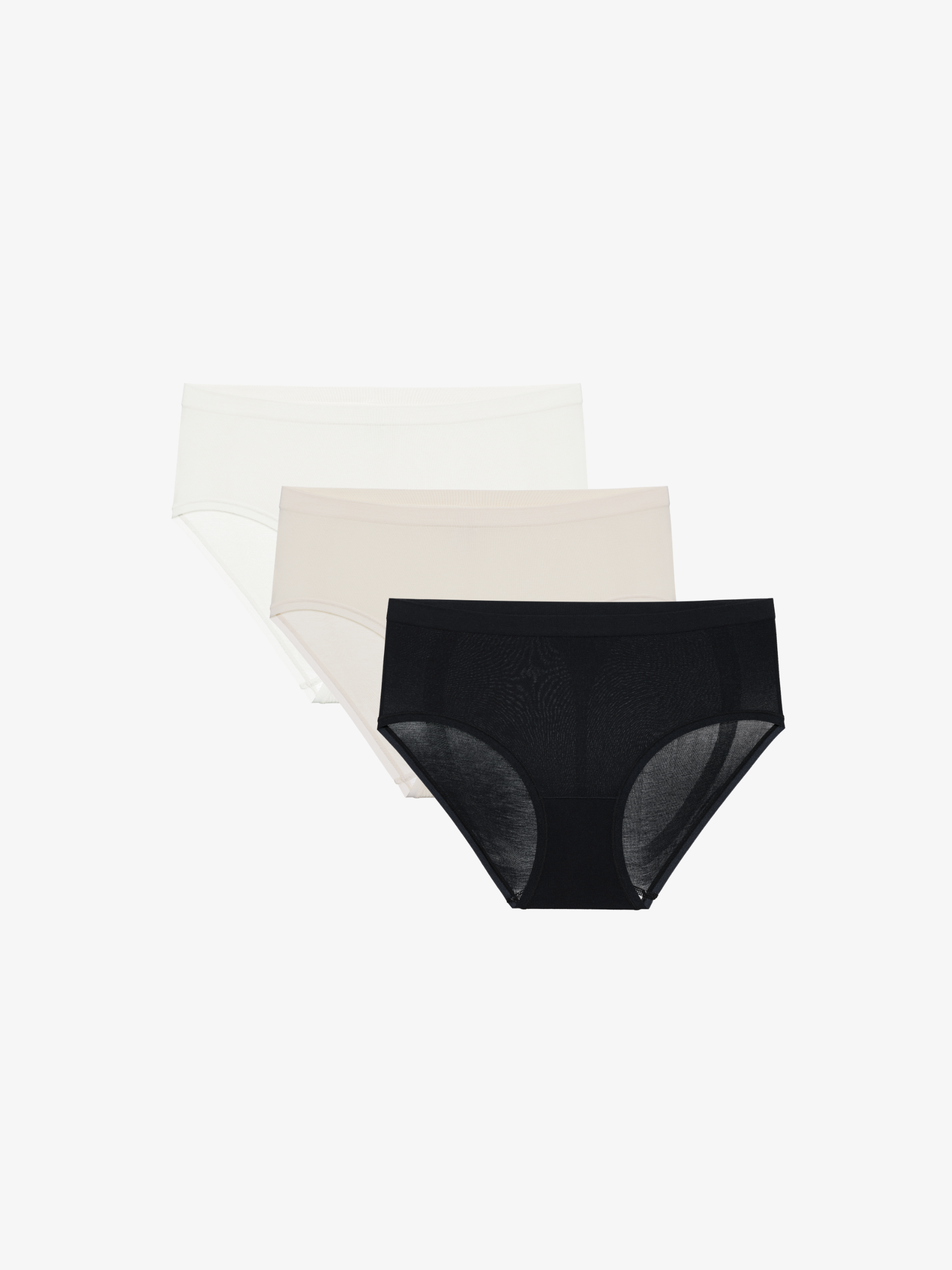 Set of white, black, and beige underwear on a white background.