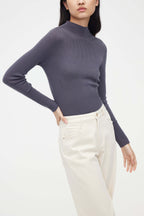 woman in purple mock neck sweater