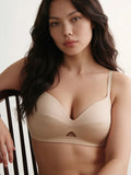 Woman wearing a beige bra against a neutral background. Ecru