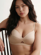 Woman wearing a beige bra against a neutral background. Ecru