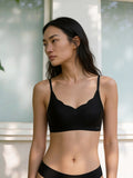 Model wearing a black bra and shorts outdoors. Black color.