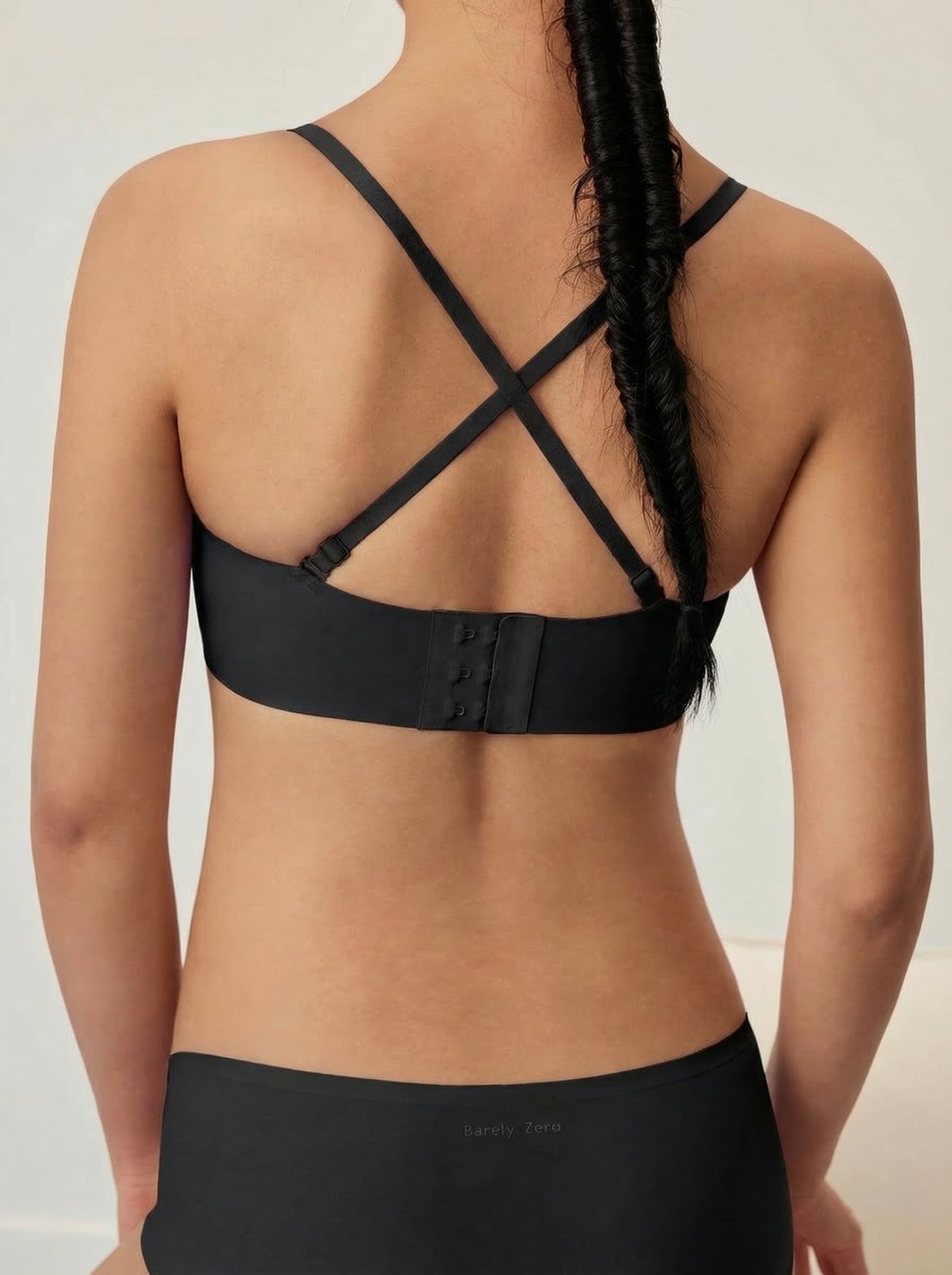 Black sports bra worn by a person on a plain background
