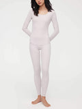 Woman wearing light gray thermal top and pants