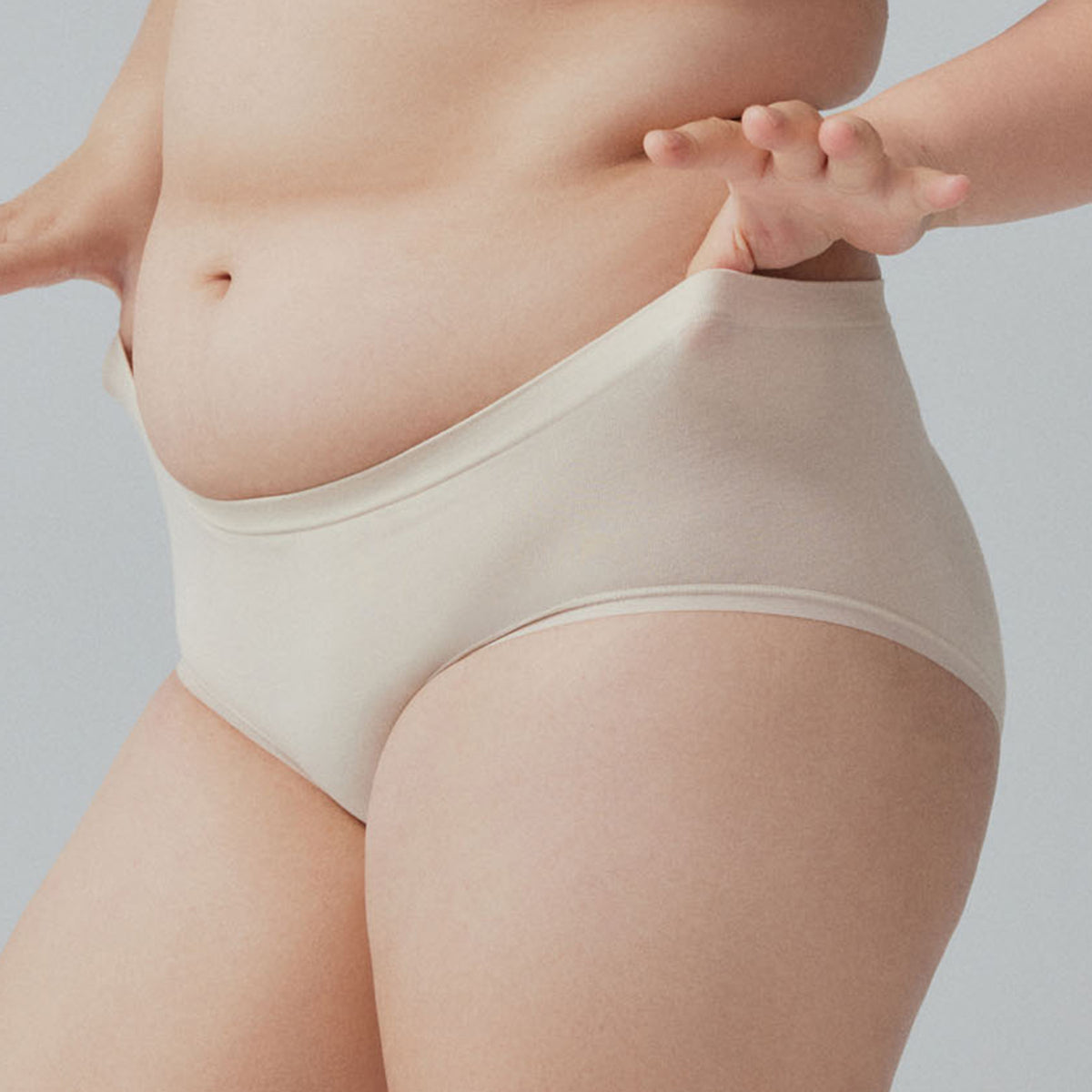 a woman wearing a pair of off-white panties with white background