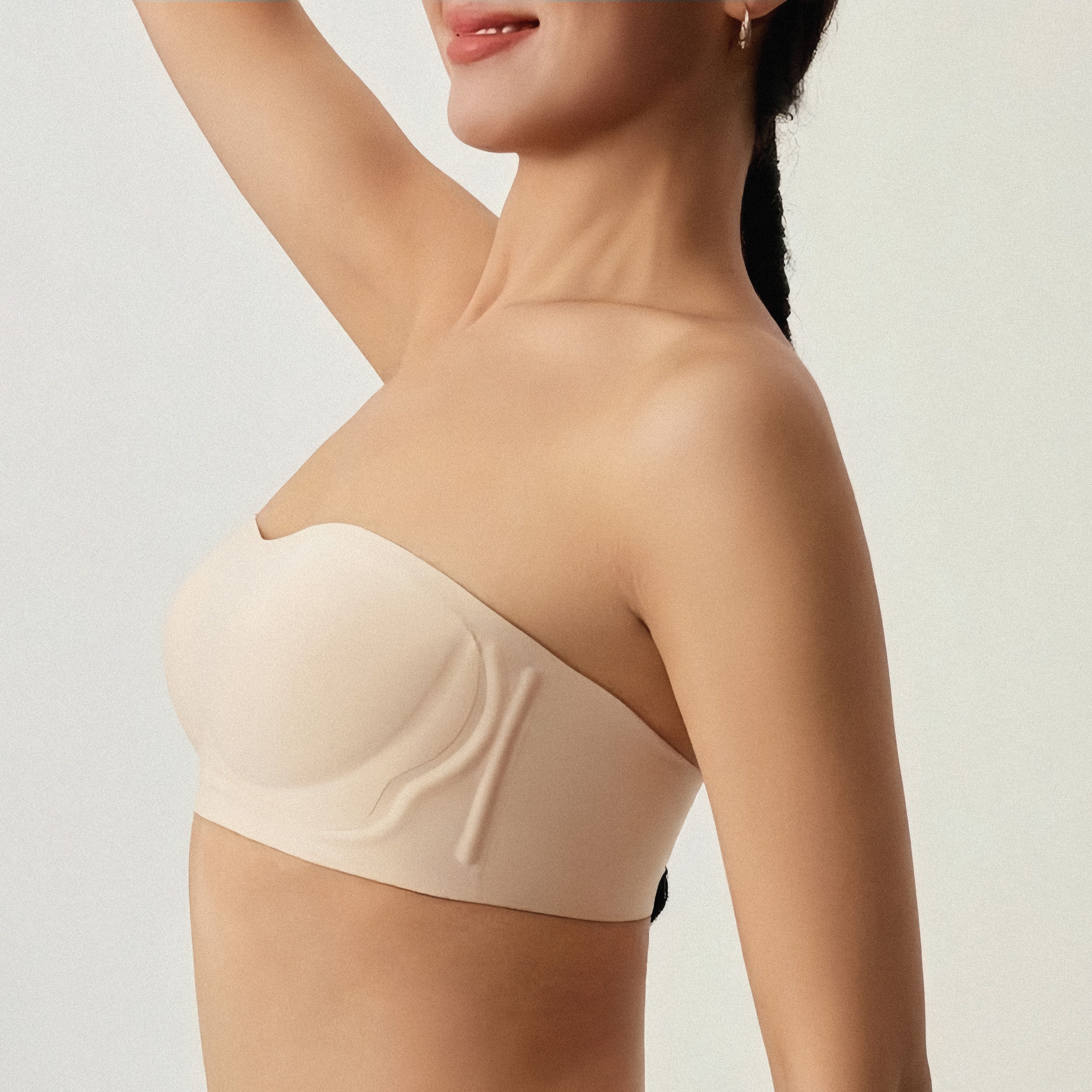 Beige strapless top worn by a model on a plain background