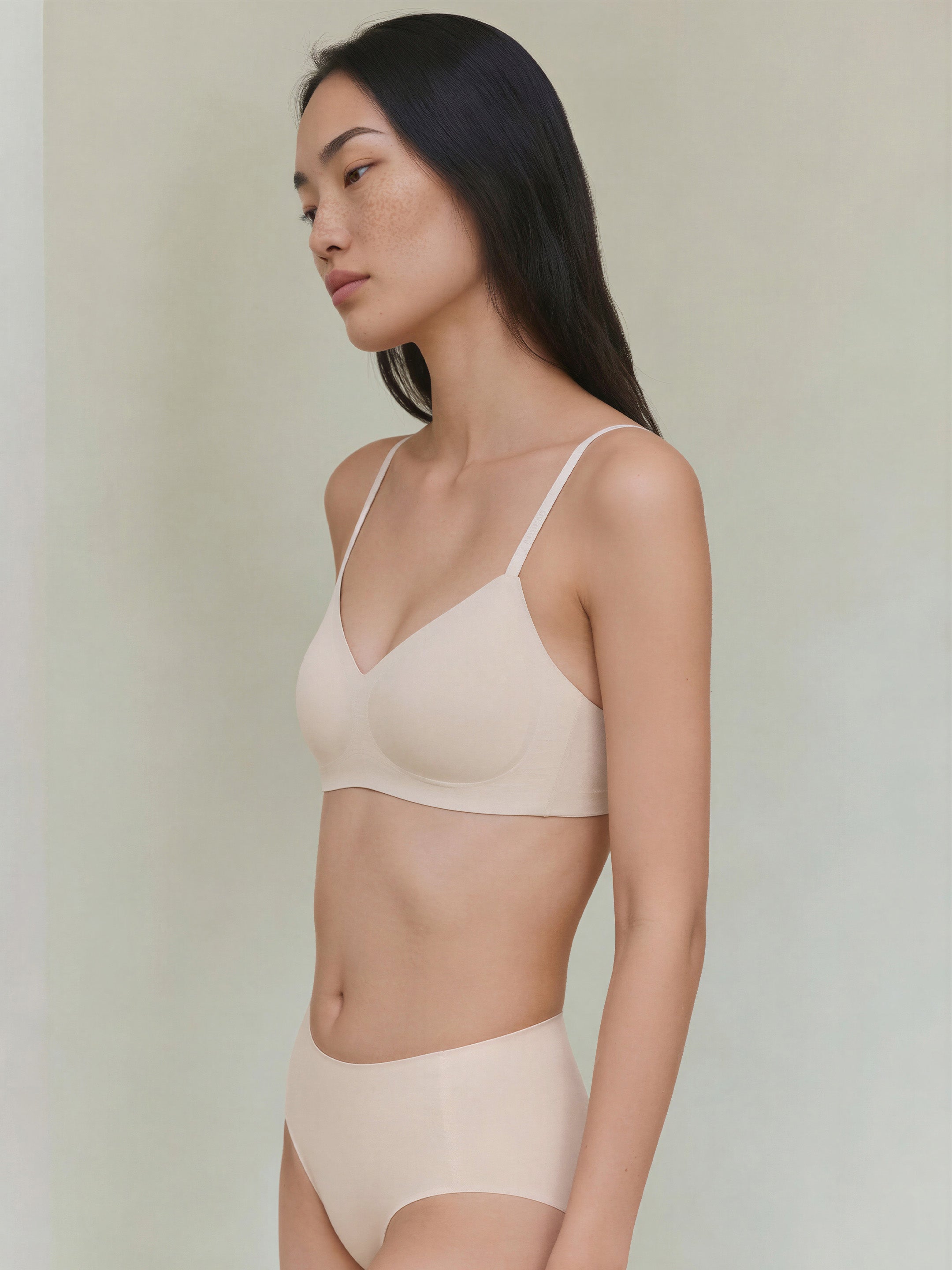 Woman wearing a beige bra and panties set against a plain background. Sugar Swizzle color.