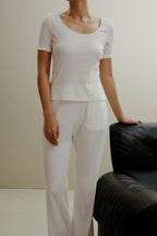 women in the white ribbed top and pants