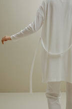 back of women in white ribbed cardigan and pants