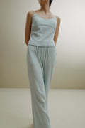 Women in the pale blue ribbed pajama cami and pants