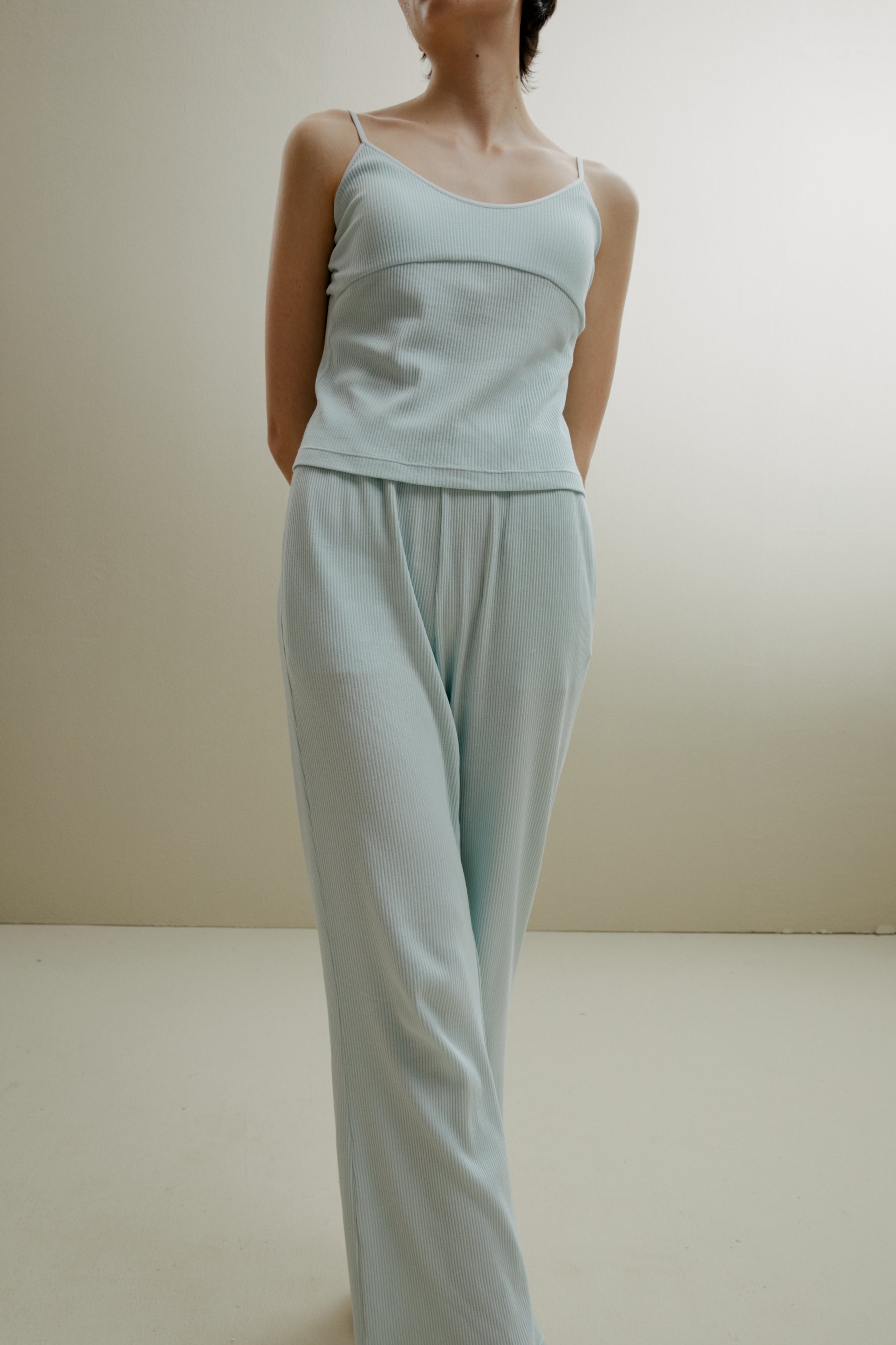 Women in the pale blue ribbed pajama cami and pants