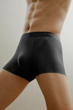 Bottom half of man wearing dark gray boxer briefs made from ribbed fabric