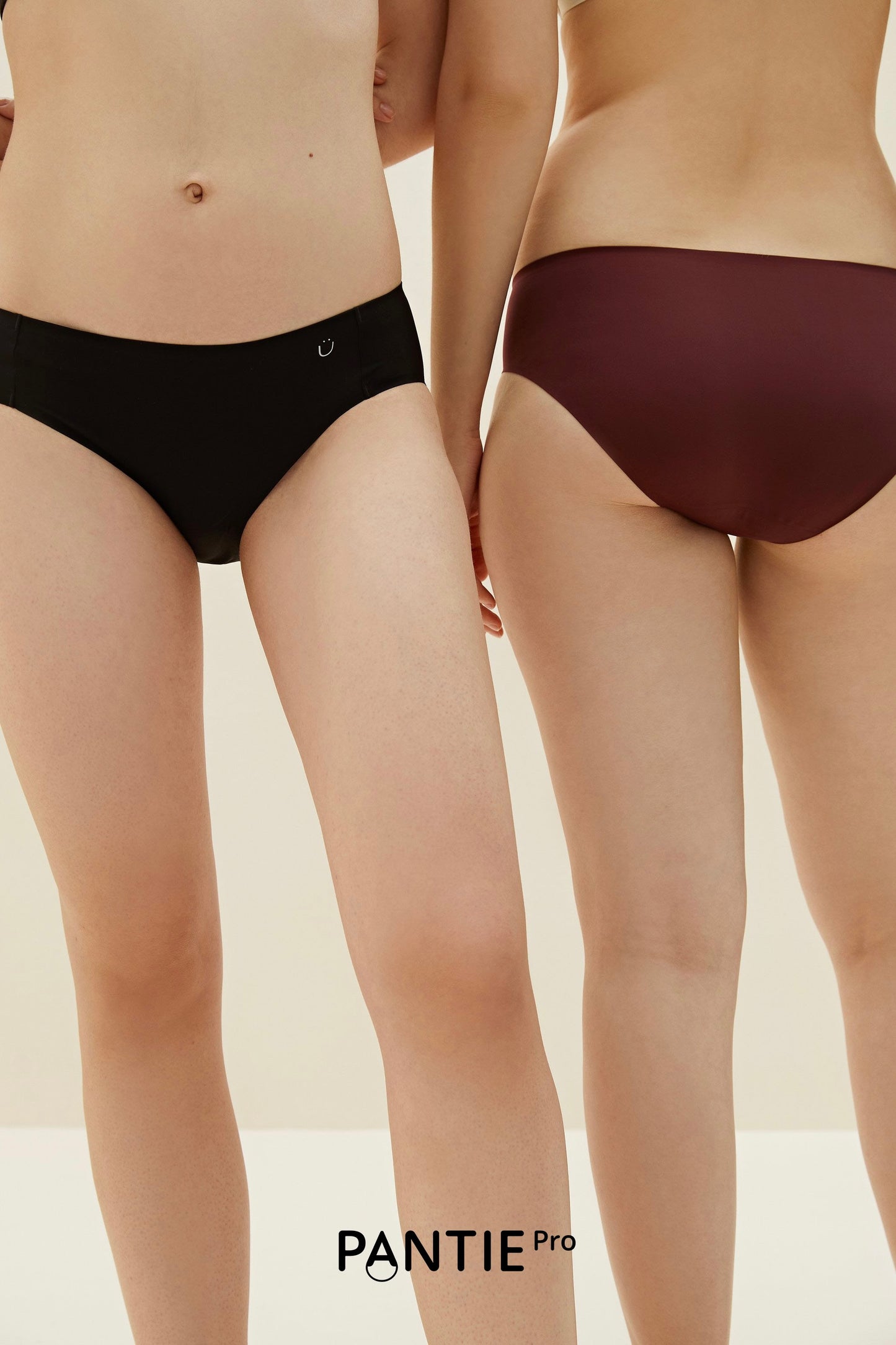 two women in underwear, one in black and one in maroon