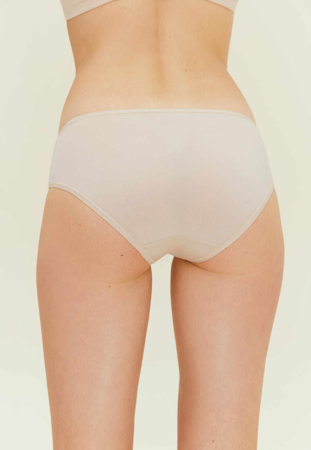 back of woman in beige brief