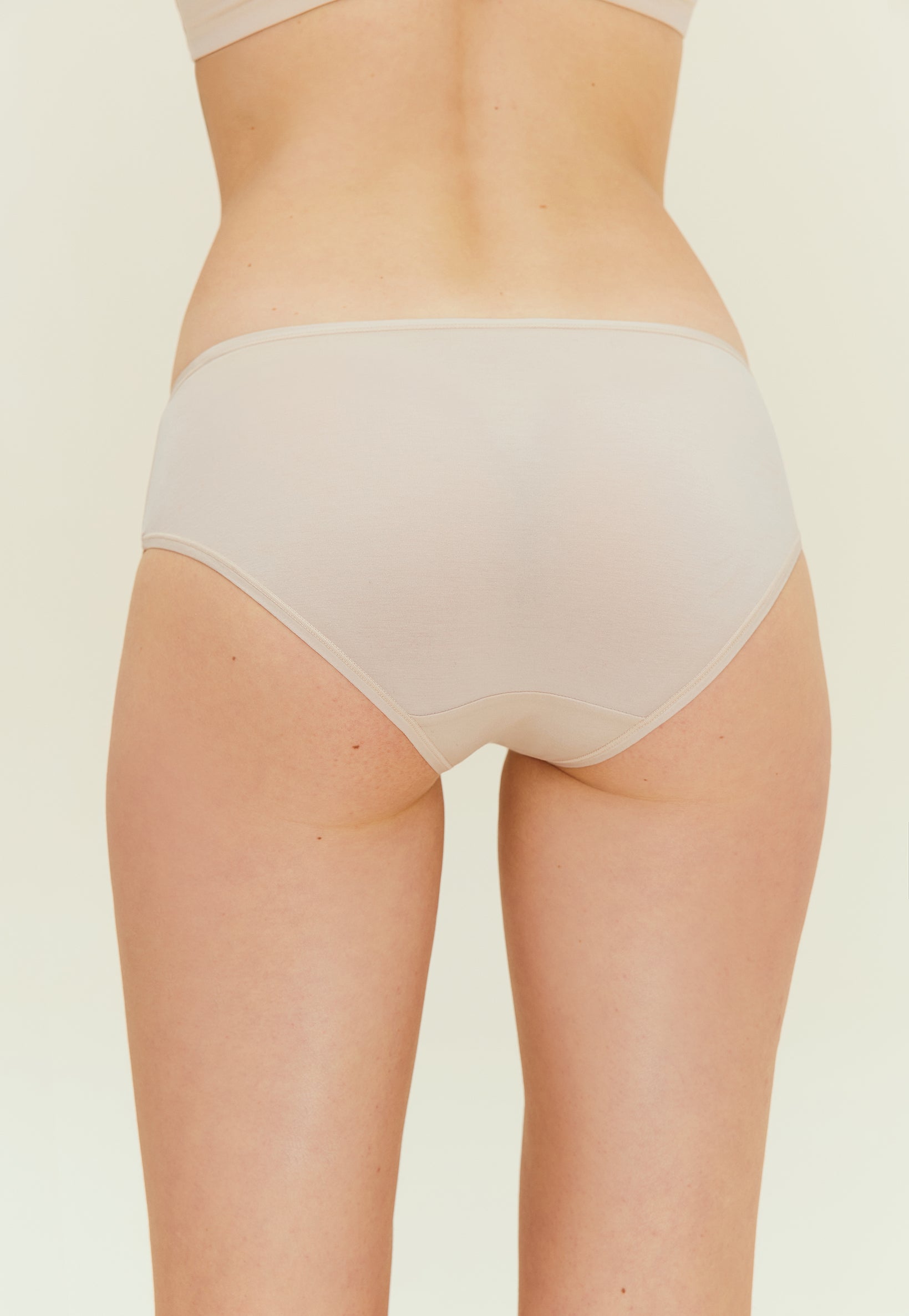back of woman in beige brief