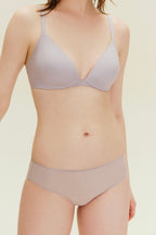 Front view of woman wearing taupe bra and brief.