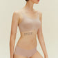 a woman wearing light nude spaghetti strap bra and midwaist seamless brief.