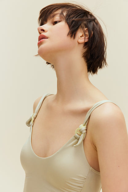 upper body of woman in light golden swimsuit