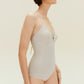 Side view of woman wearing gold one piece swimsuit with spaghetti straps and keyhole neckline design