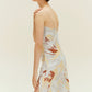 Side view of woman wearing spaghetti strap dress with brown, beige, white print